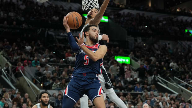 Washington Wizards guard Tyus Jones (5) looks to pass under the arm of San Antonio Spurs center Victor Wembanyama (1) in the second half at Frost Bank Center in San Antonio on Jan. 29, 2024.